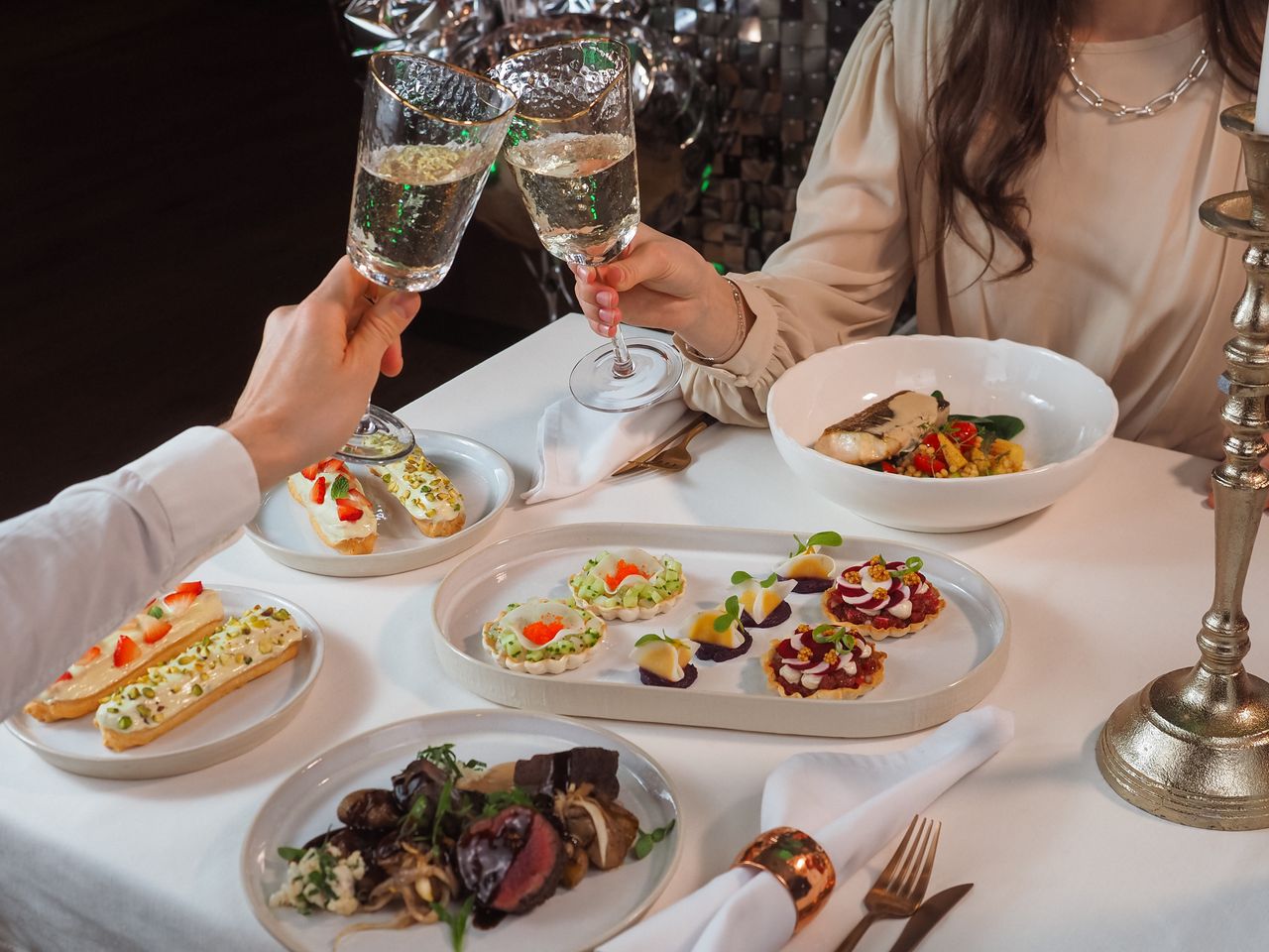 A sophisticated dining experience with gourmet dishes and a wine toast between a couple.